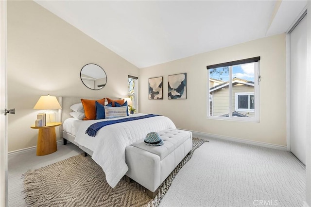 bedroom with carpet floors, multiple windows, and lofted ceiling