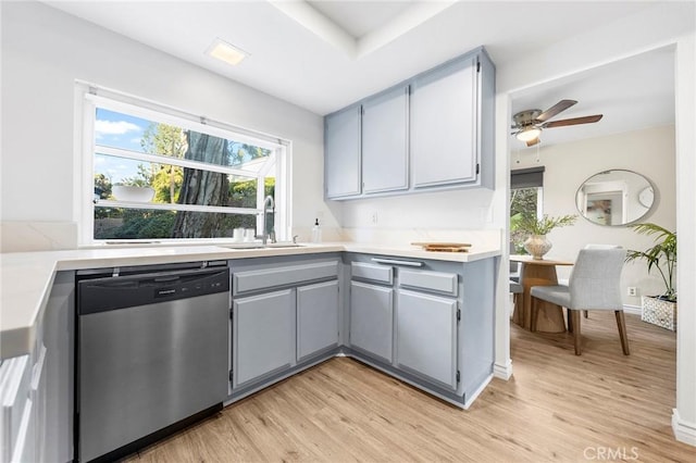 kitchen with gray cabinets, ceiling fan, light wood-type flooring, dishwasher, and sink