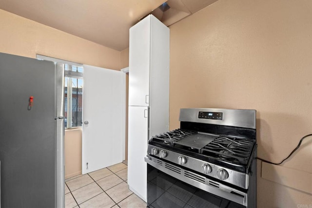 kitchen with white cabinetry, light tile patterned floors, and appliances with stainless steel finishes