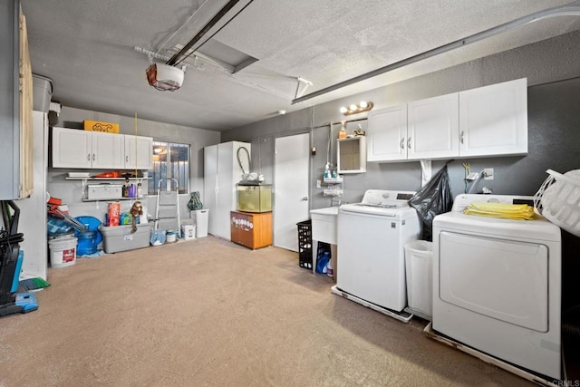 laundry area featuring cabinets, washing machine and dryer, light colored carpet, and a textured ceiling