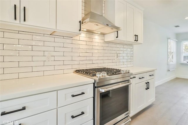 kitchen featuring white cabinets, light hardwood / wood-style flooring, decorative backsplash, gas stove, and extractor fan