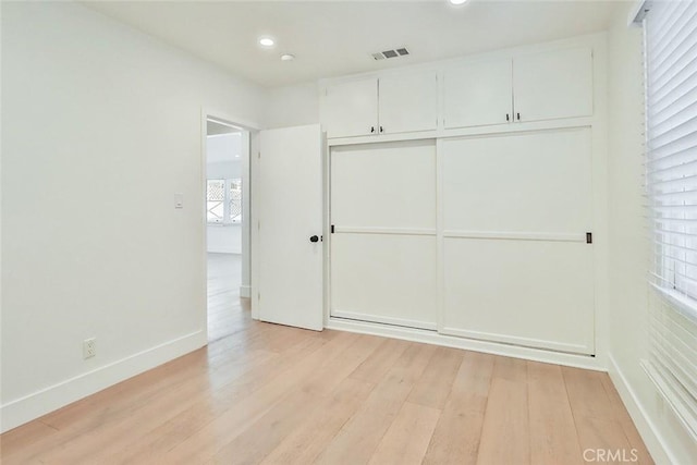 unfurnished bedroom featuring a closet and light hardwood / wood-style flooring