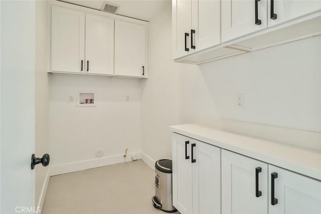 laundry room with hookup for a washing machine, cabinets, hookup for a gas dryer, and light tile patterned floors