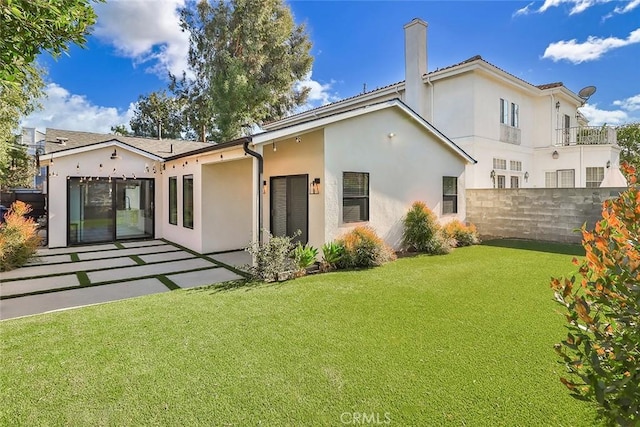 rear view of property with a yard and a patio