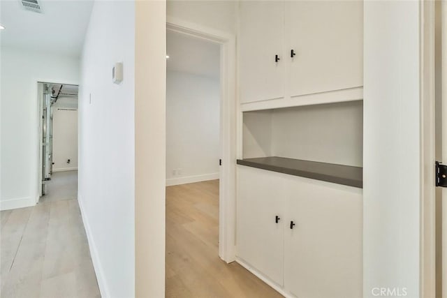 corridor with light hardwood / wood-style floors