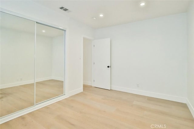 unfurnished bedroom featuring a closet and wood-type flooring