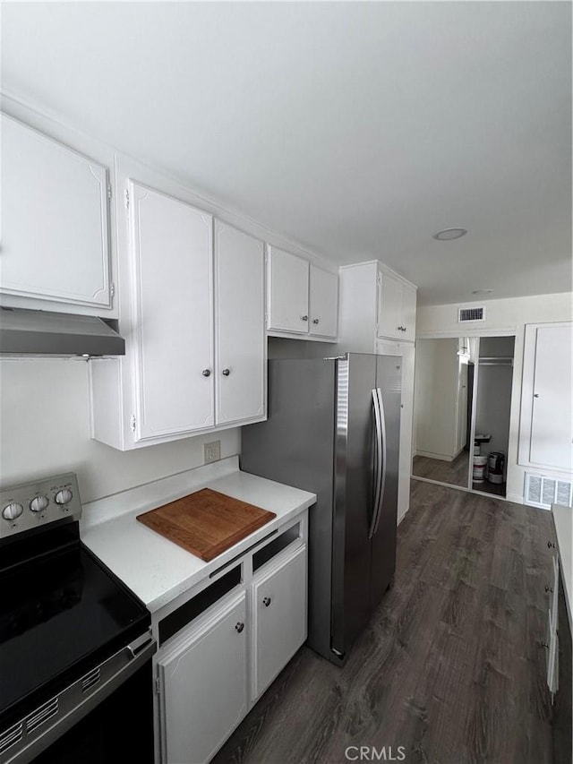 kitchen featuring dark wood-type flooring, white cabinets, stainless steel refrigerator, and electric stove