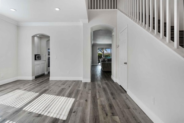 interior space with dark hardwood / wood-style flooring and crown molding