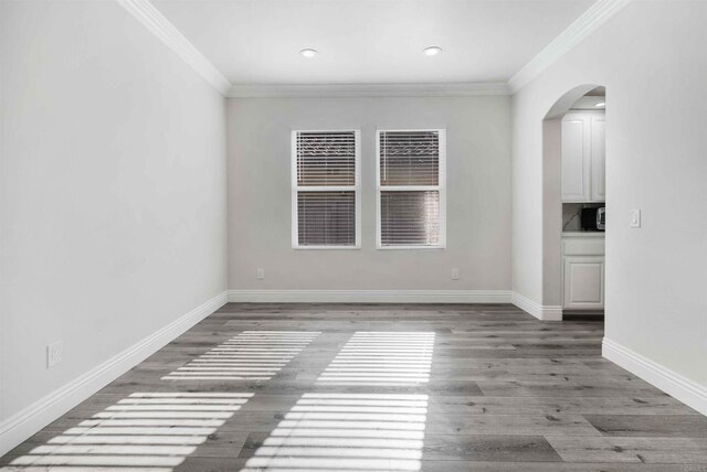 spare room with wood-type flooring and ornamental molding