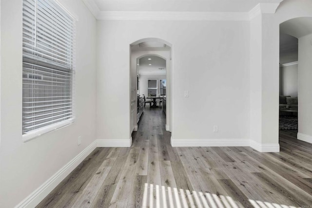 hallway with crown molding and light hardwood / wood-style floors