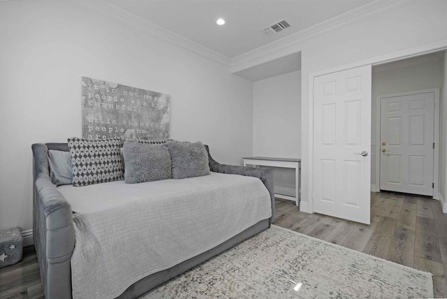 bedroom featuring ornamental molding and hardwood / wood-style floors