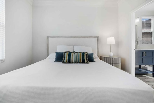 bedroom featuring ensuite bathroom and hardwood / wood-style floors