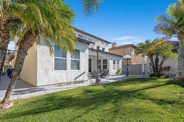 rear view of property featuring a lawn