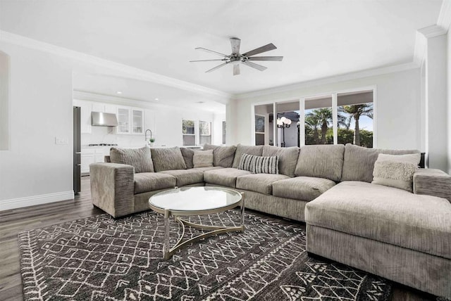 living room featuring ceiling fan, sink, dark hardwood / wood-style floors, and crown molding