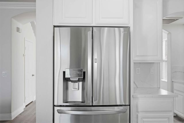 kitchen featuring white cabinetry, light hardwood / wood-style floors, and stainless steel fridge