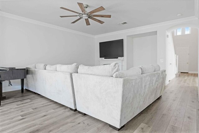 living room featuring light hardwood / wood-style floors, ornamental molding, and ceiling fan