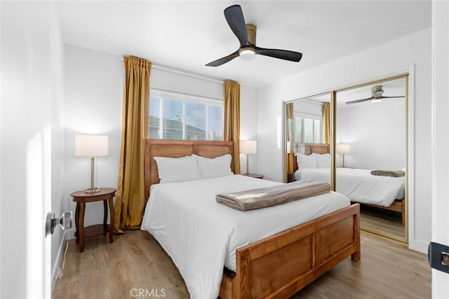 bedroom with ceiling fan, a closet, and light hardwood / wood-style flooring