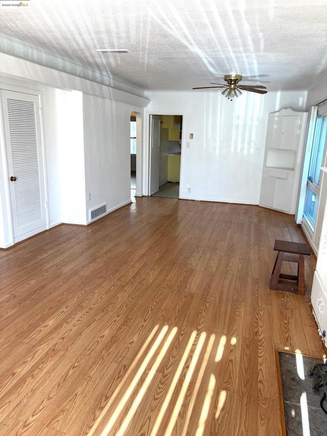 unfurnished living room featuring ceiling fan, wood-type flooring, and a textured ceiling