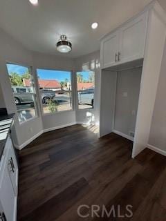 unfurnished dining area featuring dark wood-type flooring