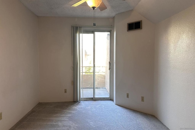 spare room featuring ceiling fan, a textured ceiling, carpet floors, and vaulted ceiling