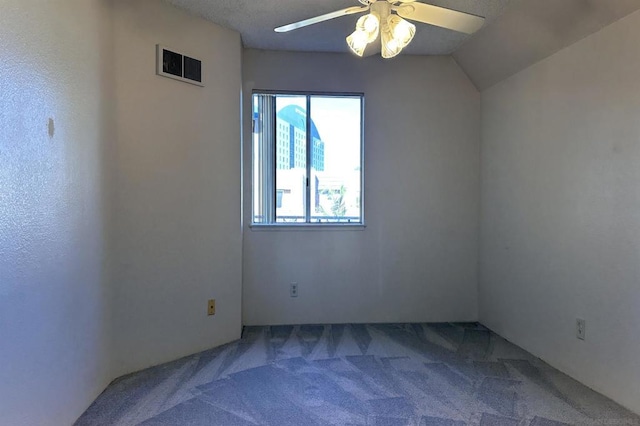 carpeted spare room featuring ceiling fan and lofted ceiling