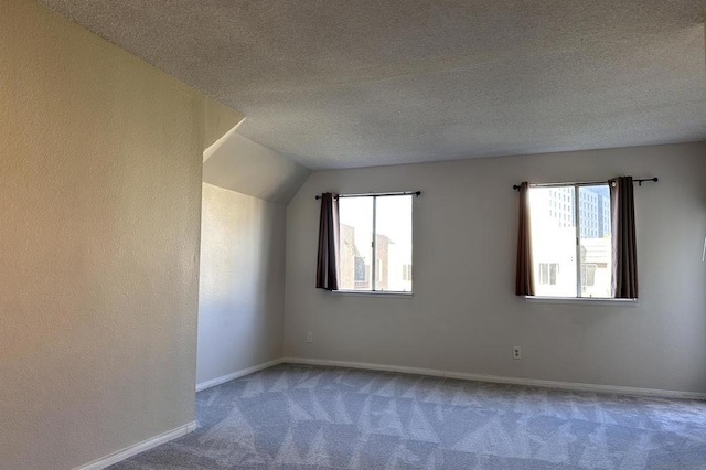 bonus room with a textured ceiling, a wealth of natural light, carpet, and vaulted ceiling