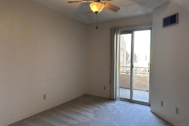 spare room featuring ceiling fan, light colored carpet, and a textured ceiling