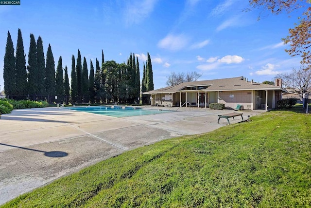 view of pool with a lawn and a patio