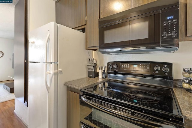 kitchen featuring black appliances and light hardwood / wood-style floors