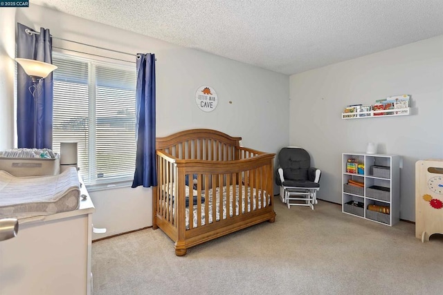 carpeted bedroom featuring a textured ceiling and a crib