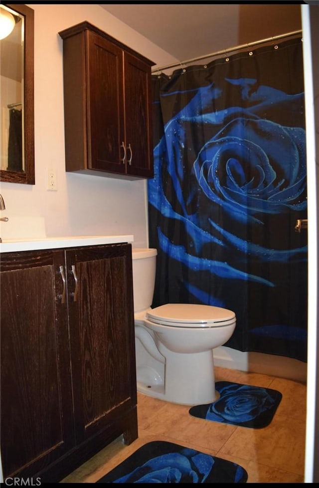 bathroom featuring toilet, vanity, tile patterned flooring, and a shower with shower curtain