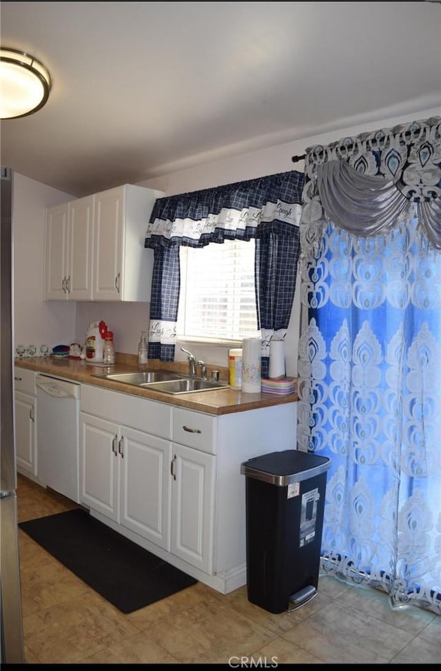 kitchen with white cabinets, dishwasher, and sink