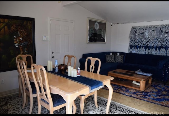 dining space featuring vaulted ceiling