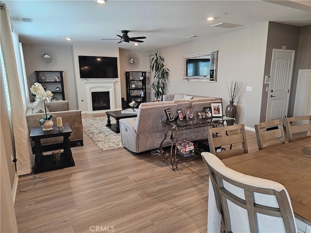 living room with ceiling fan and light hardwood / wood-style flooring