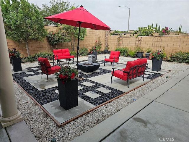 view of patio with an outdoor living space with a fire pit