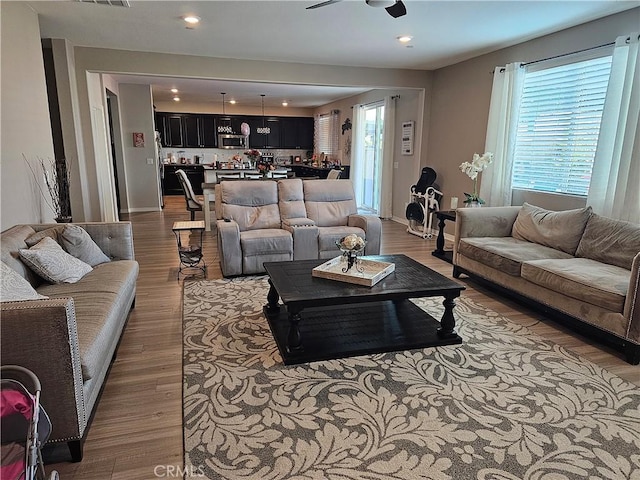 living room with ceiling fan and light hardwood / wood-style flooring