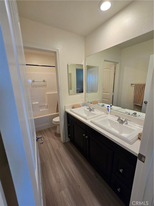 full bathroom featuring shower / bathing tub combination, wood-type flooring, toilet, and vanity