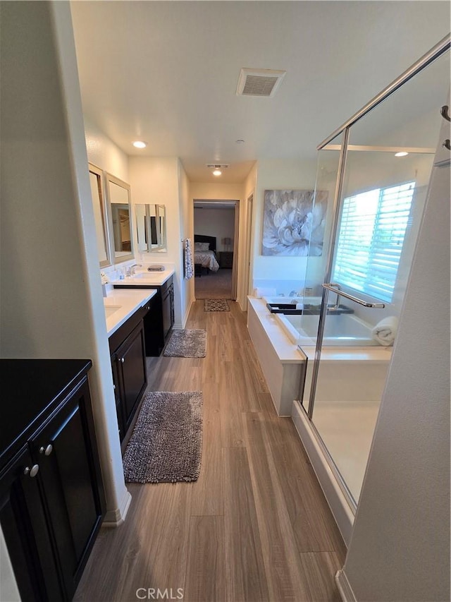 bathroom with vanity, independent shower and bath, and hardwood / wood-style flooring