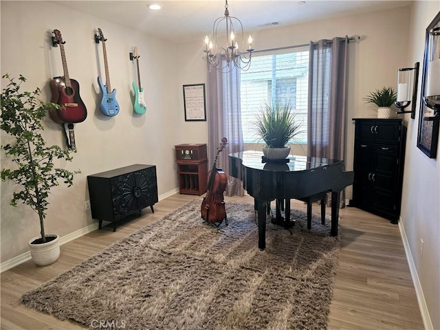 miscellaneous room with light wood-type flooring and an inviting chandelier