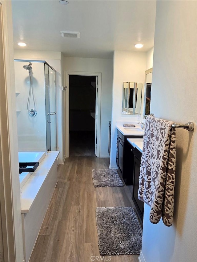 bathroom featuring vanity, independent shower and bath, and hardwood / wood-style flooring