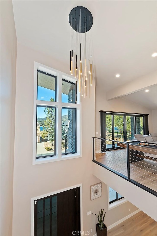 details with a notable chandelier, beamed ceiling, and hardwood / wood-style floors