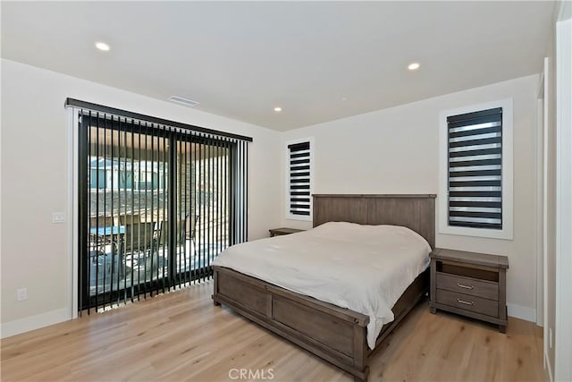 bedroom with access to exterior, light hardwood / wood-style floors, and multiple windows