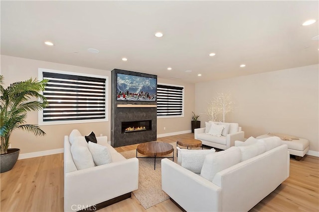 living room with light hardwood / wood-style flooring and a tiled fireplace