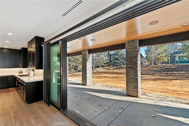 doorway with light hardwood / wood-style floors and sink