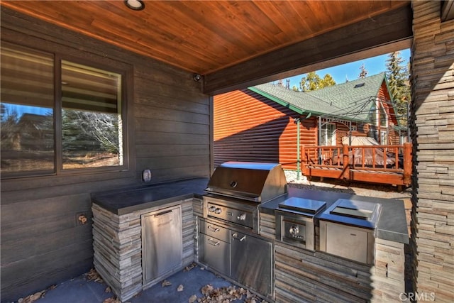 view of patio / terrace with an outdoor kitchen, a wooden deck, and area for grilling