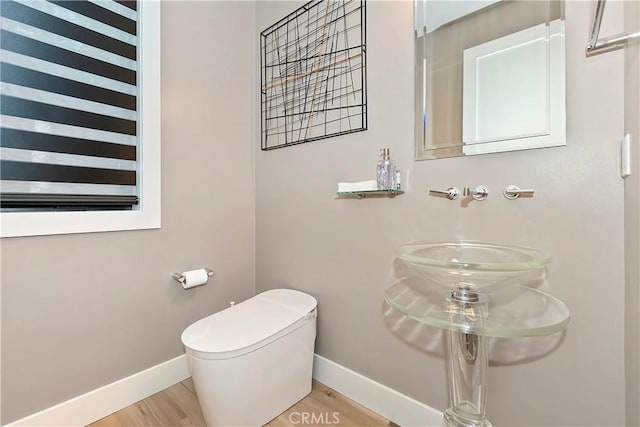 bathroom with toilet and hardwood / wood-style floors