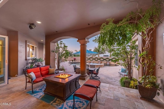 patio terrace at dusk featuring an outdoor living space with a fire pit