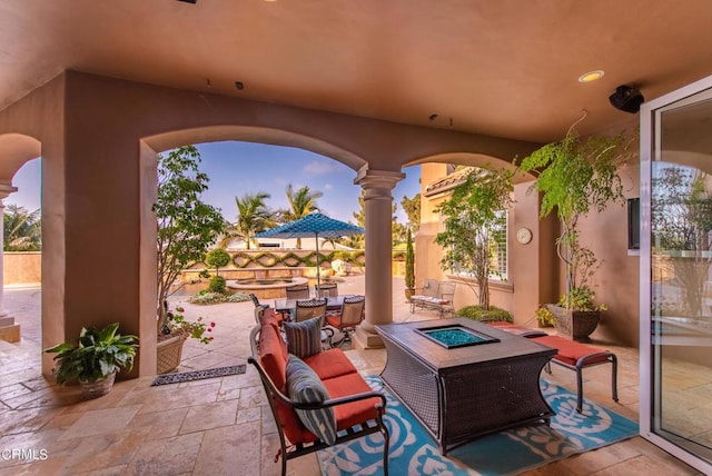 patio terrace at dusk featuring an outdoor living space with a fire pit