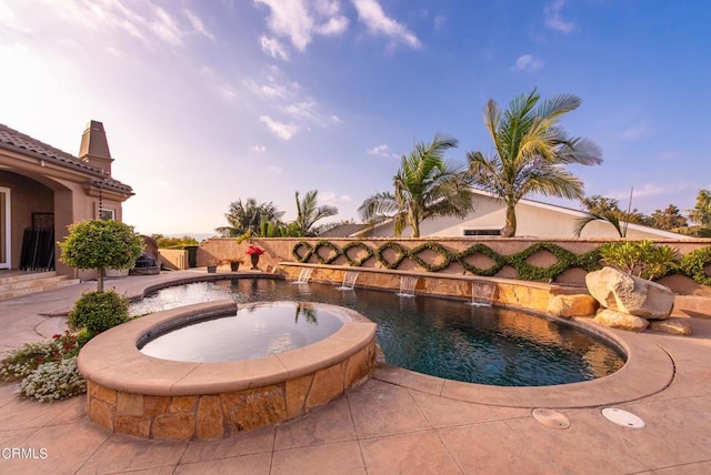 view of swimming pool featuring pool water feature and an in ground hot tub