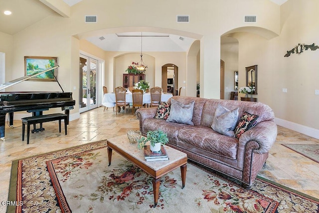 living room with lofted ceiling with beams and french doors